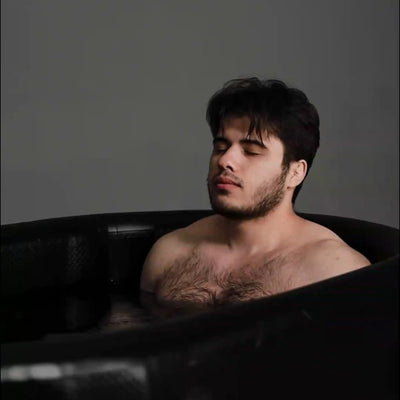 Garvnive black PVC ice bath tub with an air-filled insulation layer; a man is undergoing cold therapy for recovery.